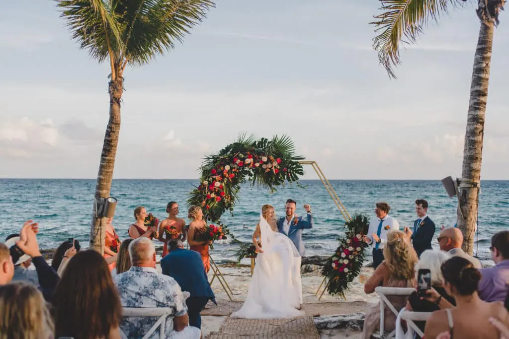 bride and groom getting married on beach at hotel xcaret mexico. yellow umbrella events